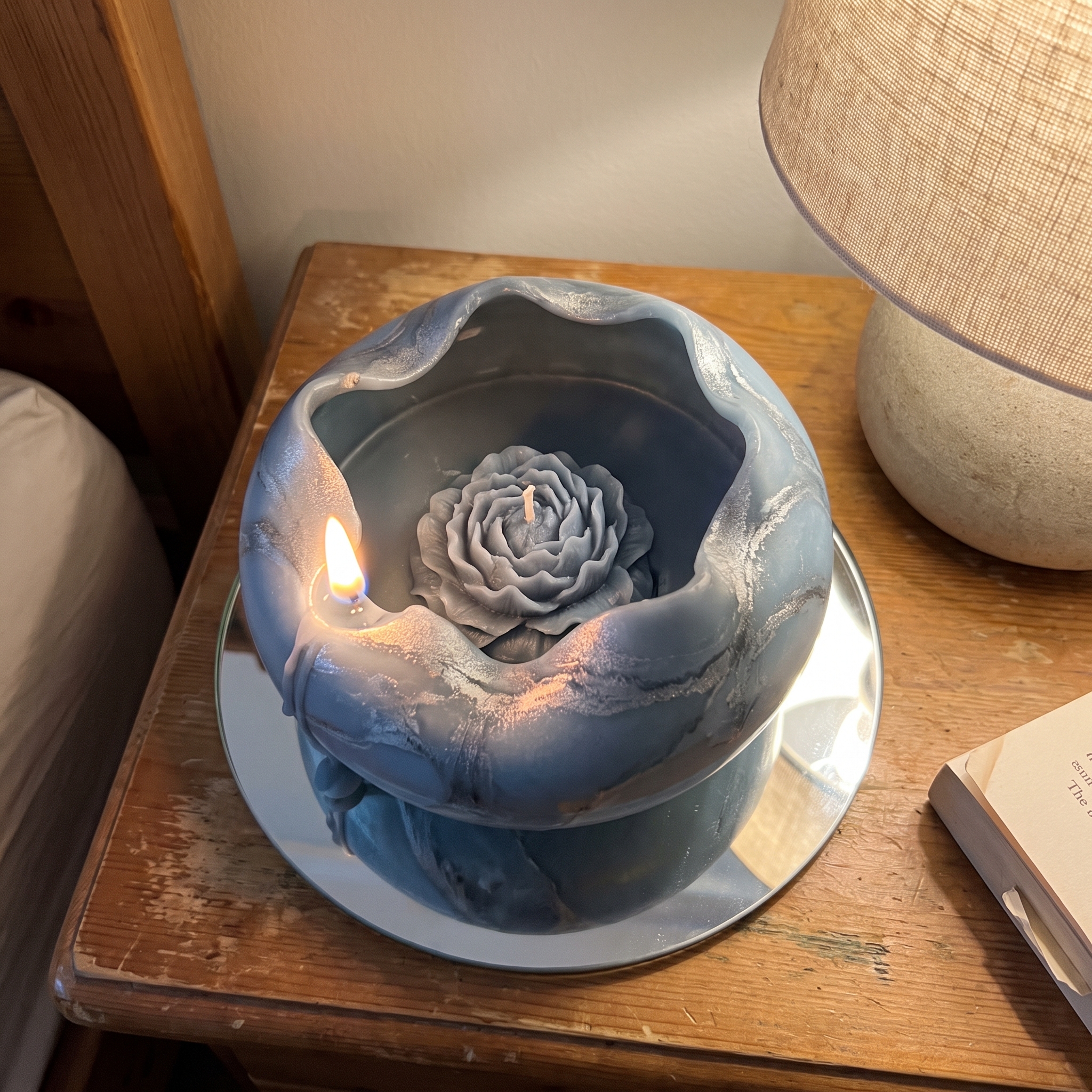 Blue marbled spiral candle with a peony inside made by a student