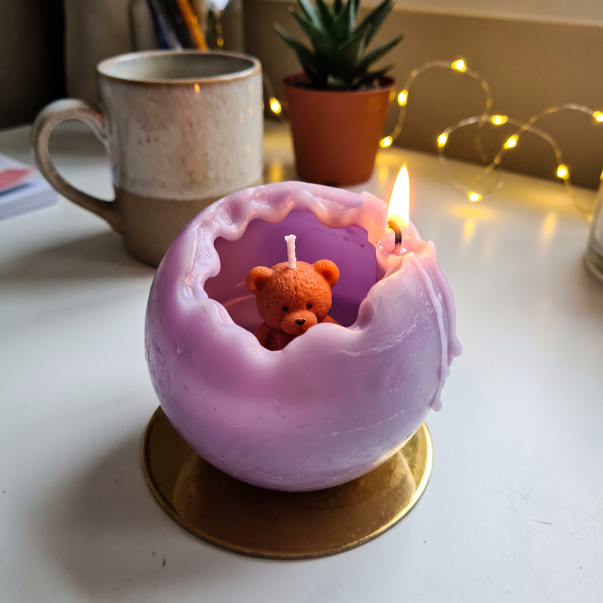 Lilac spiral candle with a small teddy bear inside made by a student